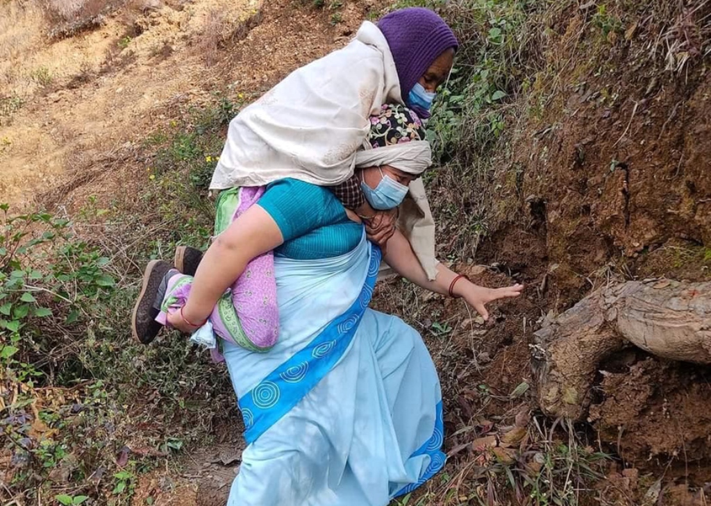 गुल्मीमा  ७८ वर्षीया वृद्धालाई स्वास्थ्य स्वयंसेविकाले बोकेर पुर्‍याइन् खोप केन्द्र